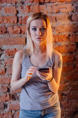 Pretty hipster girl near the brick wall