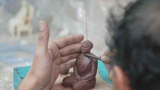 Artist making plasticine female figure prototype before making mold