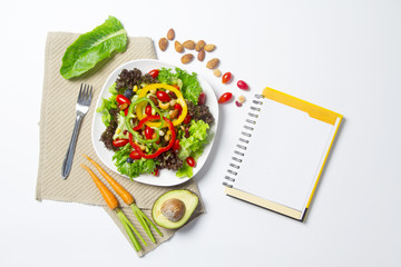 Fototapeta na wymiar fresh vegetable salad with notebook paper