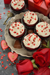 Cupcakes, chocolate and rose on a gray background