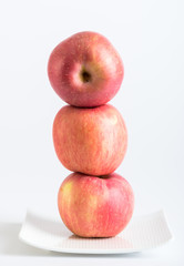Fresh red apples in plate on white background
