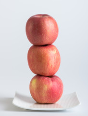 Fresh red apples in plate on white background