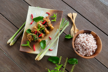 Stir-fried chicken with basil and rice on wood table