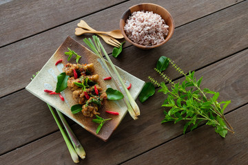 Stir-fried chicken with basil and rice on wood table