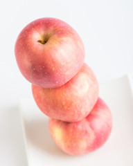 Fresh red apples in plate on white background