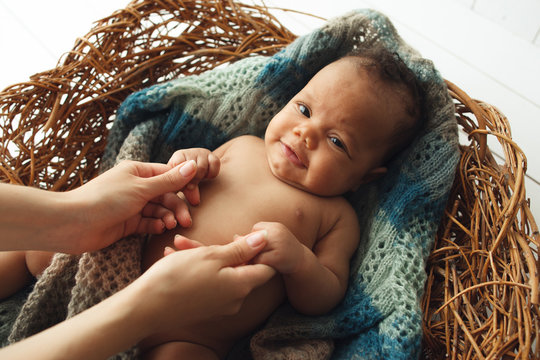 Cute Newborn Baby Holding Mom Hands In Cradle. Top View On Adorable Child In Wicker Nest With Mother Arms. New Life, Love, Happiness Concept