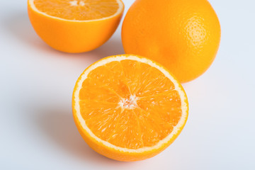 Fresh orange and cut in half on white background