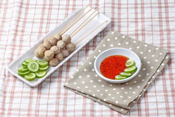 Grilled pork meatball skewers served cucumber and sweet chili sa