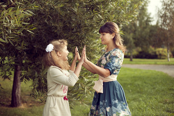 Obraz premium Teen girl plays with mom's hands in the summer on the nature, re