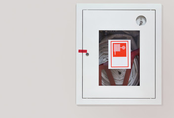 Wall mounted fire hose in an easily accessible box