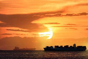 Logistics and transportation of International Container Cargo ship with tugboat in the ocean at...
