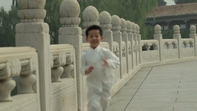 WS Young boy running along stone balustrade / Beijing, China