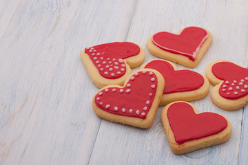 Red cookies in the shape of a heart on wooden boards close-up on Valentine's Day