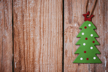 Green cardboard christmas tree on wood background, greeting card template, wallpaper, vintage