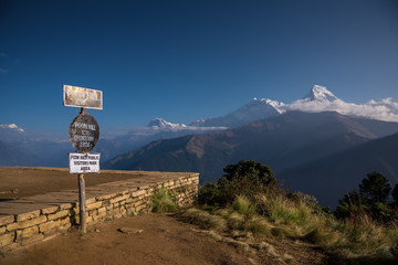 Poon hill altitude sign with Annapurna range in background, Nepal.