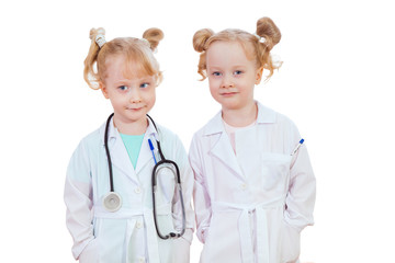 beautiful little girl twins playing doctors isolated on white background