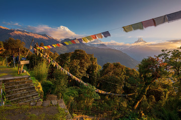 View of Mt. Annapurna and prayer flags at Sunrise from Tadapani, Nepal.