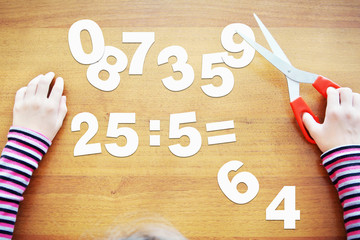 Little girl is learning to divide. Concept with paper scrapbooking
