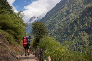 Fototapeta na wymiar Porter carrying two heavy duffle bag in Annapurna base camp ,Nepal.