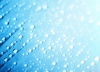 Blue water drops of on treat water-repellent surface in macro lens shot small-DOF for screen...