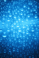 Fototapeta na wymiar Blue water drops of on treat water-repellent surface in macro lens shot small-DOF for screen wallpapers