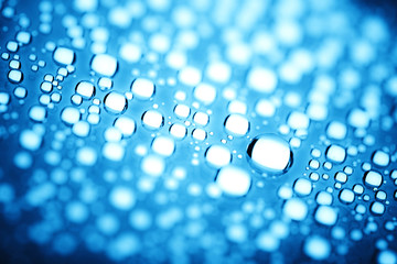 Blue water drops of on treat water-repellent surface in macro lens shot small-DOF for screen...