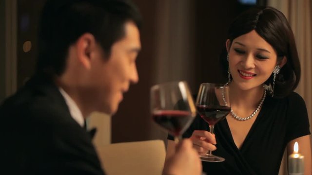 MS Couple toasting with wine glasses at candle lit dinner / China
