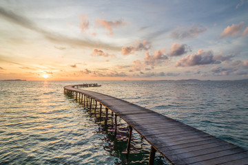 Obraz premium Pastel sunset behind a lonely wooden jetty