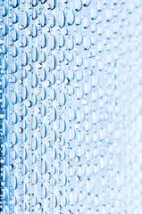 Blue water drops of on treat water-repellent surface in macro lens shot small-DOF for screen...