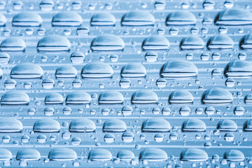 Fototapeta premium Blue water drops of on treat water-repellent surface in macro lens shot small-DOF for screen wallpapers