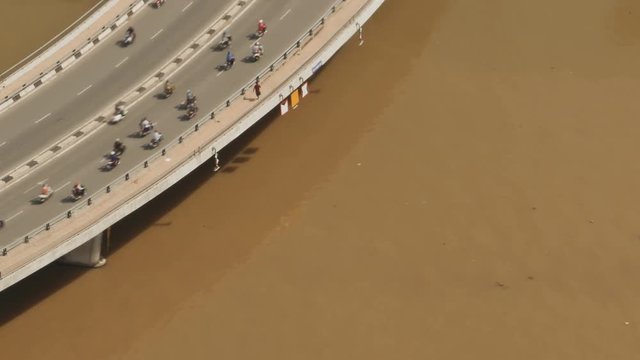 Bridge across the Saigon River from road traffic. Brown river.