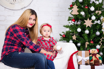 woman and her daughter sitting in decorated living room with Chr