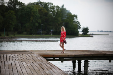 Fototapeta na wymiar Woman in red jumpsuit at lake