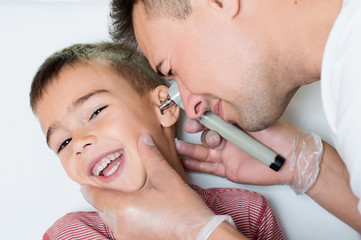 Doctor explores the ear to smiling child