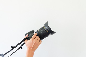 Camera in hand. Close-up of hand holding camera while isolated o