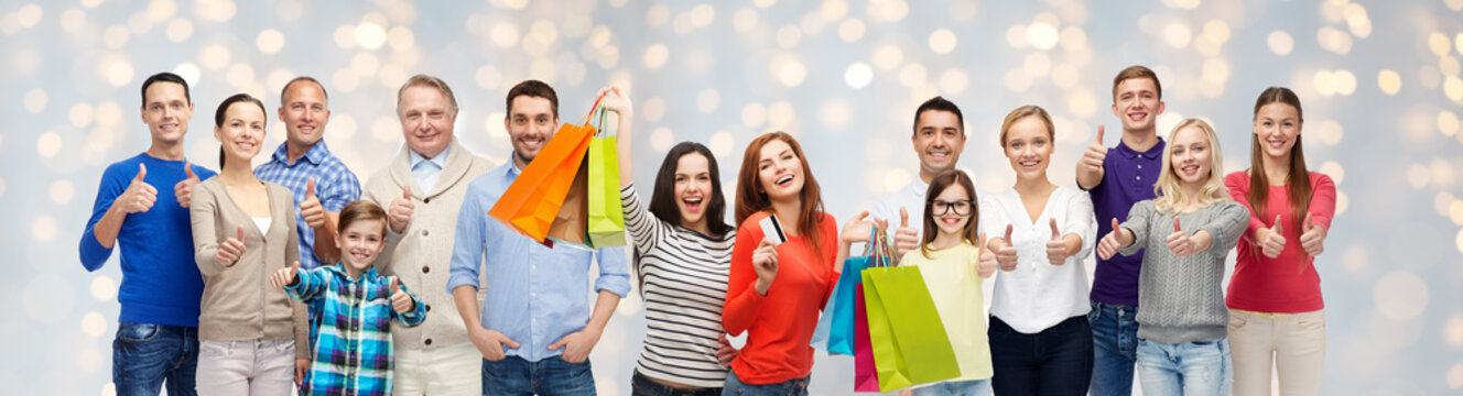 happy people with shopping bags showing thumbs up
