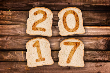 2017 greeting card toasted slices of bread on wooden planks background