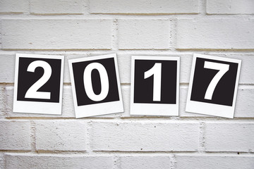 2017 in instant photo frames on a brick wall