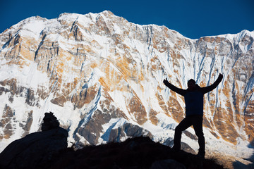 Silhouette backpacker on the rock and Annapurna I Background (8,091m) from Annapurna Basecamp ,Nepal. - 127042427