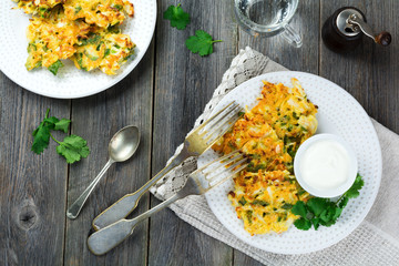 Pancakes with cabbage and spinach on a white ceramic plate on old wooden background. Rustic style. Selective focus.Top view. Place for text.