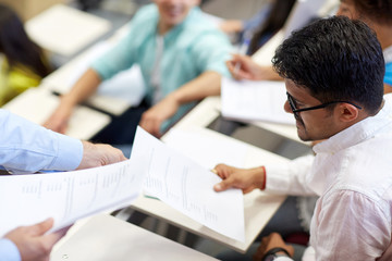 teacher giving exam test to student man at lecture