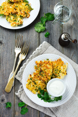 Pancakes with cabbage and spinach on a white ceramic plate on old wooden background. Rustic style. Selective focus.Top view. Place for text.