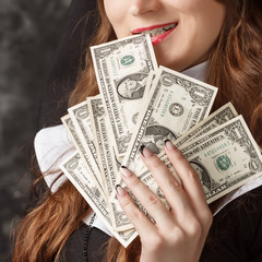 close-up of a woman holding dollar bills in her hand and pulls out his teeth one dollar