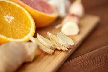 ginger, garlic and orange on wooden board