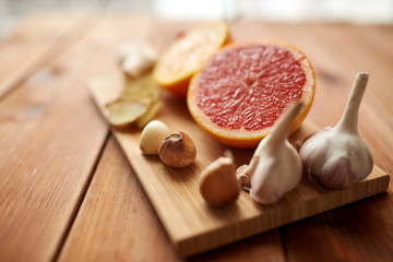garlic and grapefruit on wooden board