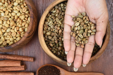 coffee beans with cinnamon sticks and ground coffee in wooden spoon for background