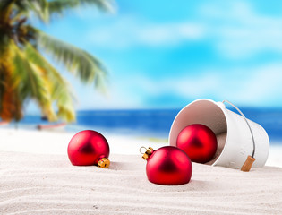 Christmas balls, ornament on a beach - concept of a warm weather Christmas celebration