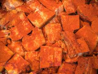 Background of the pieces of smoked lard. Orange smoked lard pattern close up