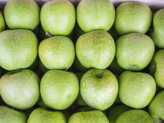 Background of green apples close up. Green apples pattern on sale at the market.