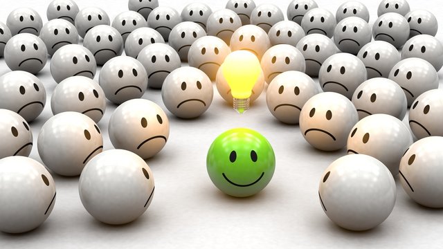 Konzept Kreativit&auml;t: gr&uuml;ner 3D Smiley mit Gl&uuml;hbirne - neidische Smiley drumherum